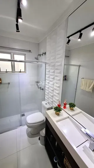 Banheiro moderno com revestimento cerâmico branco.
