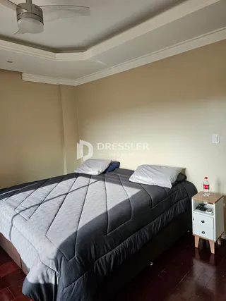 Quarto com cama grande e paredes claras.