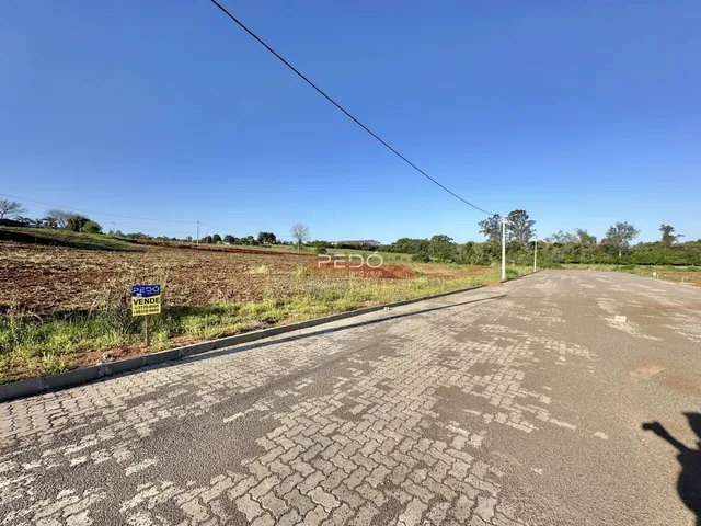 Vista da propriedade com um campo aberto e uma estrada no primeiro plano.