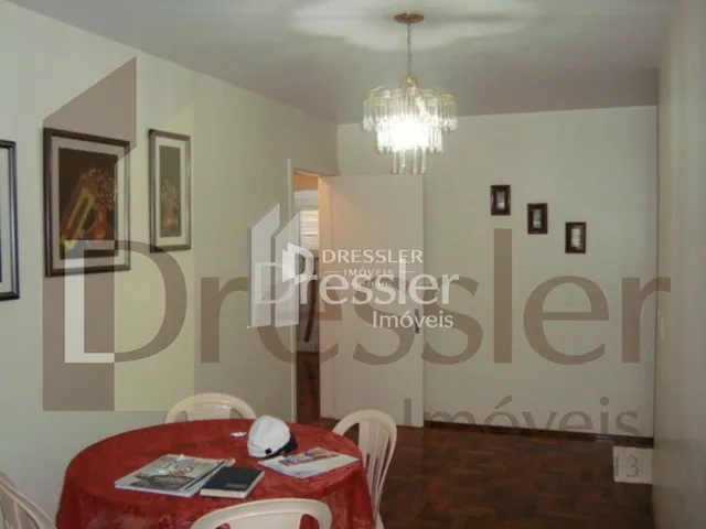 Quarto com piso de madeira e cabeceira de cama.