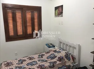 Quarto com cabeceira de madeira e cama decorada.