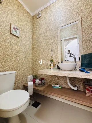 Foto interna de um banheiro com revestimento de papel de parede amarelo.