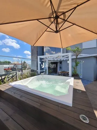 Vista externa de uma piscina com deck de madeira em uma propriedade.