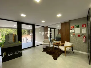 Sala de estar ampla com piso claro e portas de vidro.