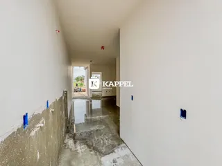 Corredor interno de uma propriedade em fase de construção com piso molhado.