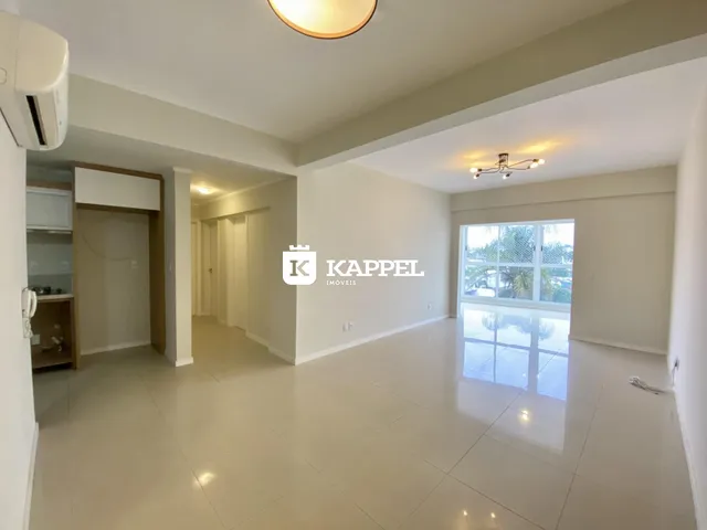 Sala de estar com piso claro e iluminação bem distribuída.