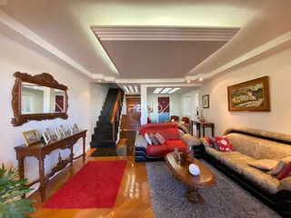 Sala de estar com piso de madeira e sofá vermelho.