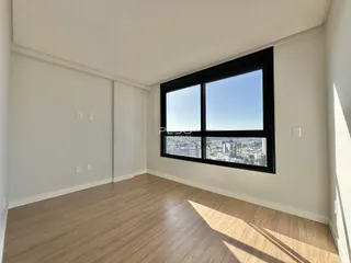 Sala de estar com grande janela oferecendo vista da cidade.