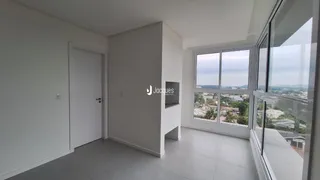 Interior de um ambiente com parede branca e janela de grande porte.