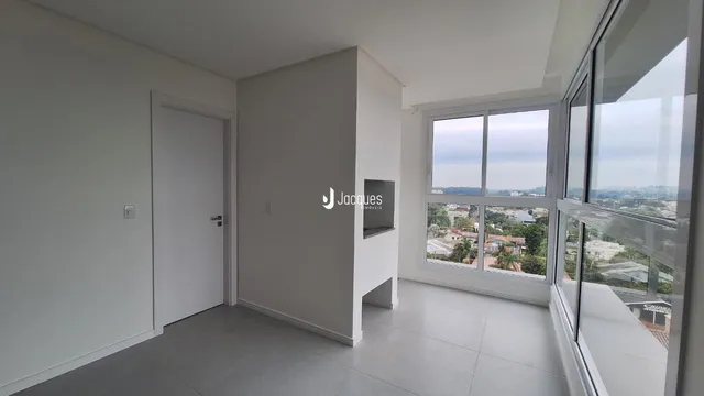 Interior de um ambiente com parede branca e janela de grande porte.