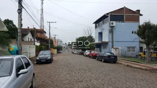 Vista da rua em Lajeado, Brasil, mostrando casas e veículos estacionados.