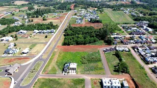 Vista aérea de uma área residencial com estradas e vegetação no Brasil.