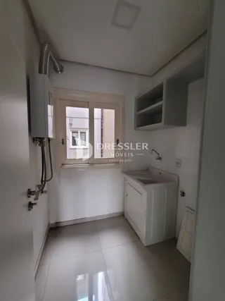 Vista de um corredor interno com piso de cerâmica e armários em uma residência.