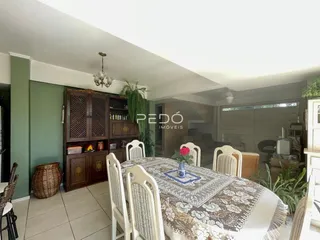 Sala de jantar com mesa de madeira e armários na área interna da residência.