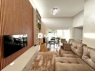 Uma sala de estar moderna com sofá grande e área de jantar ao lado.