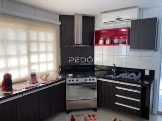 Cozinha moderna com armários escuros e bancada escura.