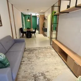Sala de estar com sofá e piso claro em um ambiente interno.