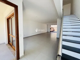 Hall de entrada com piso de cerâmica e escadaria.