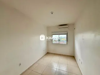 Vista interna de um cômodo com piso de cerâmica e janela para a cidade.