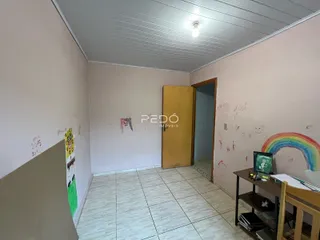Vista interna de um corredor com paredes em tom claro e piso de cerâmica.