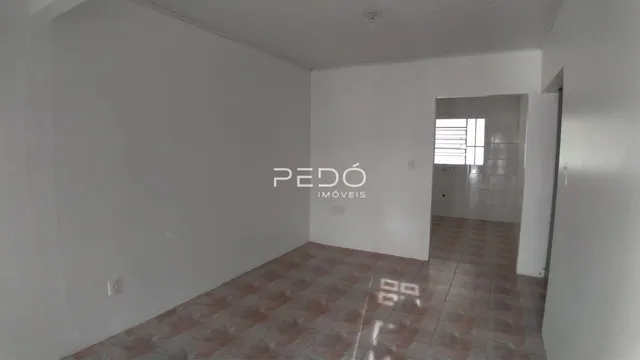 Vista interna de um ambiente com piso de cerâmica e paredes brancas.