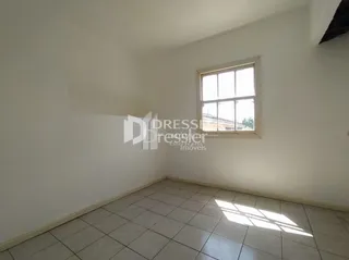 Interior de um cômodo com paredes brancas e piso de cerâmica.