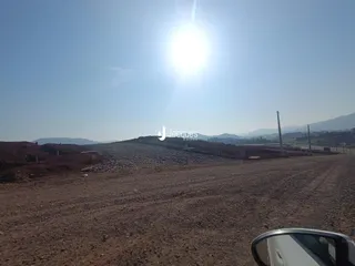 Vista panorâmica de uma paisagem árida com terreno rochoso e estrada de terra.