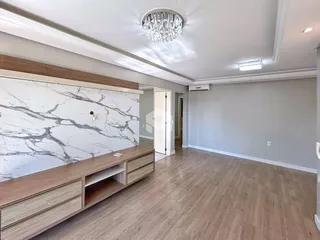 Sala de estar com parede de mármore e piso de madeira clara.