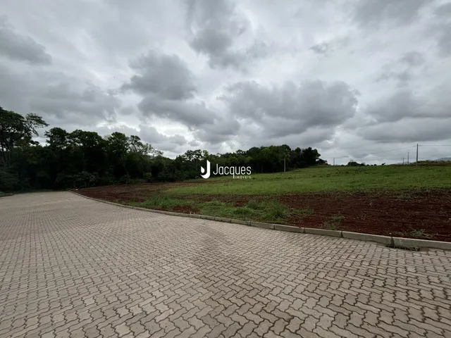 Vista externa da propriedade com área pavimentada e campo.