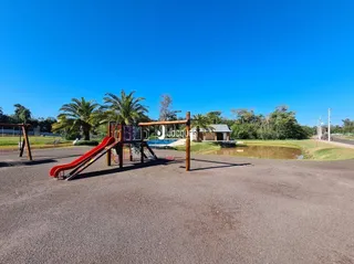 Área externa com playground e palmeiras em Lajeado.