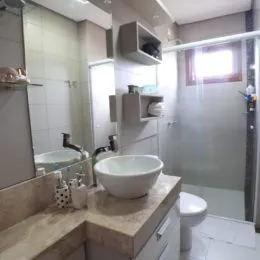 Foto de um banheiro com pia e revestimento de azulejos brancos.