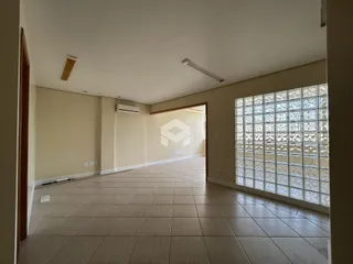 Corredor com piso de cerâmica e grande janela decorativa.