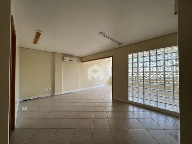 Corredor com piso de cerâmica e grande janela decorativa.