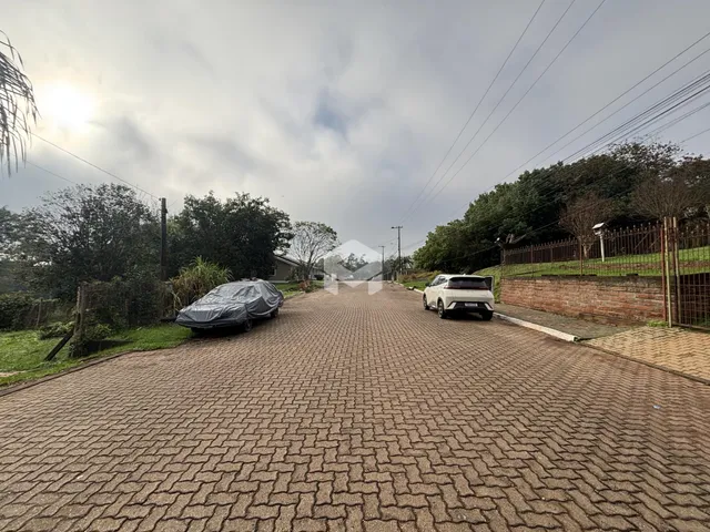 Vista da rua pavimentada em Lajeado, Brasil, com vegetação ao redor.