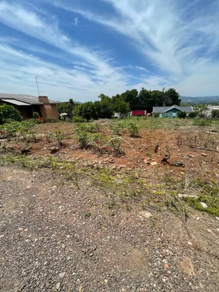 Vista externa de um terreno com solo seco e vegetação rasteira.