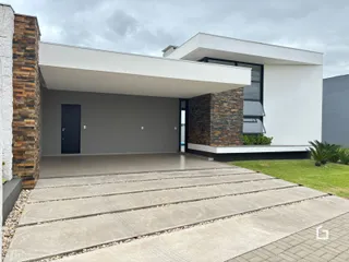Fachada moderna de uma residência em Lajeado, Brasil, com entrada coberta e área pavimentada.