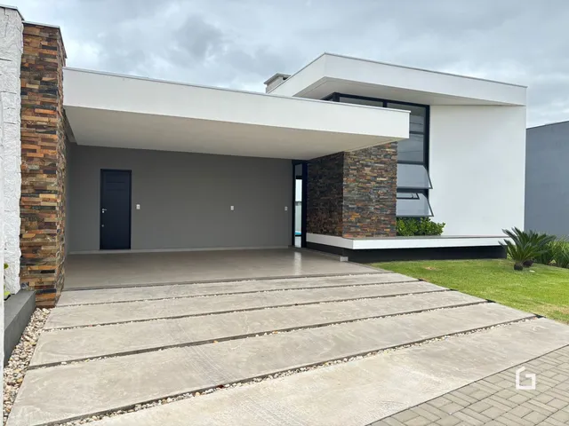 Fachada moderna de uma residência em Lajeado, Brasil, com entrada coberta e área pavimentada.