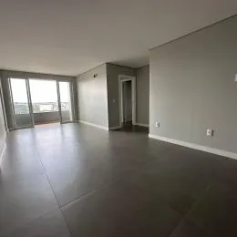 Vista interna de um ambiente com piso de concreto e portas de vidro.