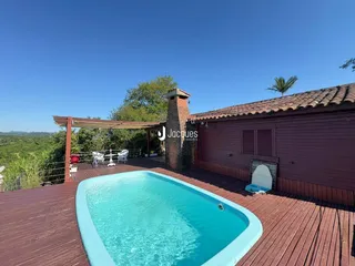 Área externa com piscina e deck de madeira em Lajeado.