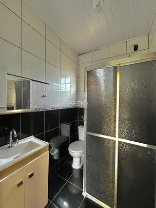 Interior de um banheiro com revestimento de azulejos brancos e pretos.