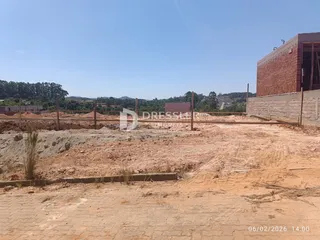 terreno em construção com cerca e muro de tijolos no fundo