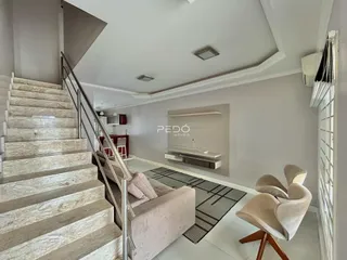 Vista de uma sala de estar com escadaria em um imóvel em Lajeado.