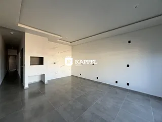 Vista interna de um ambiente com piso de porcelanato cinza e paredes brancas.