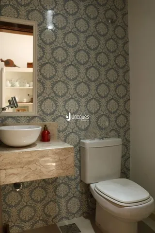 Foto de um banheiro interno com azulejos texturizados e louças sanitárias.