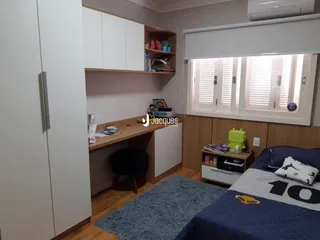 Quarto com armários brancos e piso de madeira em um imóvel em Lajeado.