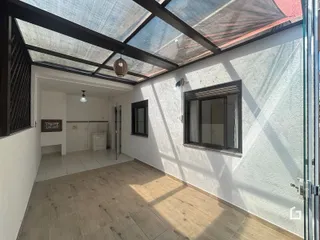 Ambiente interno com teto de vidro e piso de madeira.