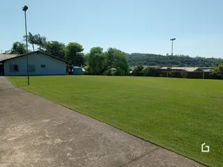 Vista externa de um gramado e área pavimentada em uma propriedade.