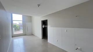 Interior de uma sala com janela e porta branca.