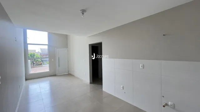 Interior de uma sala com janela e porta branca.