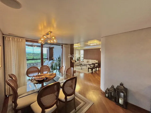 Uma sala de jantar com móveis de vime e piso de madeira clara em uma residência no Brasil.